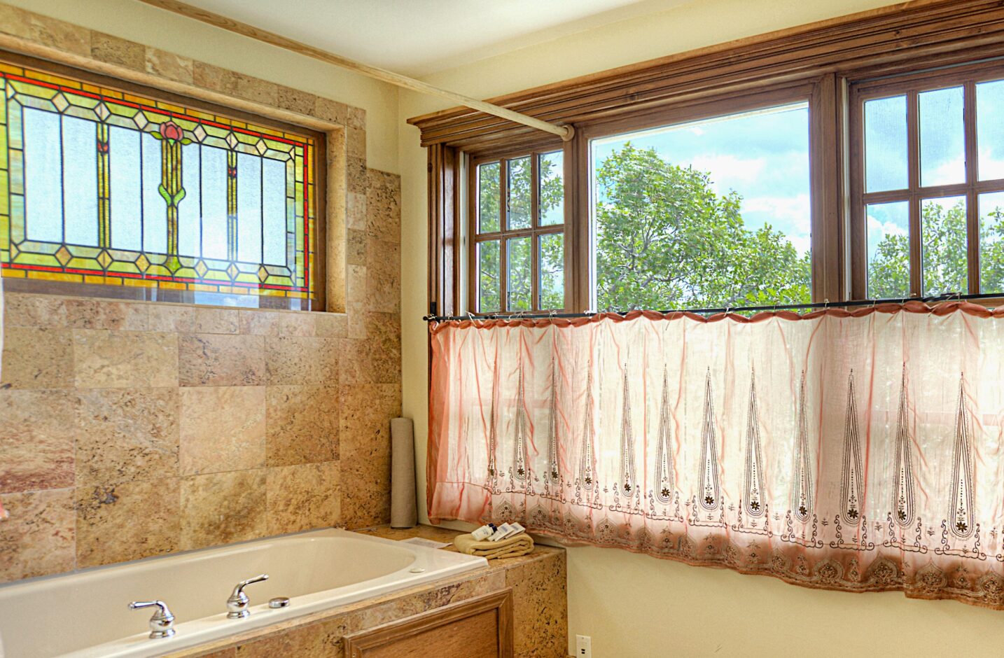 Bathroom with a large tub and windows