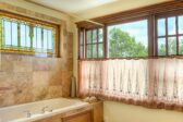 Bathroom with a large tub and windows