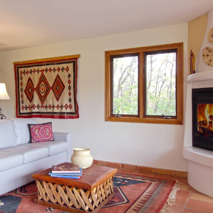 A large living room with a geometric rug a large couch and fireplace
