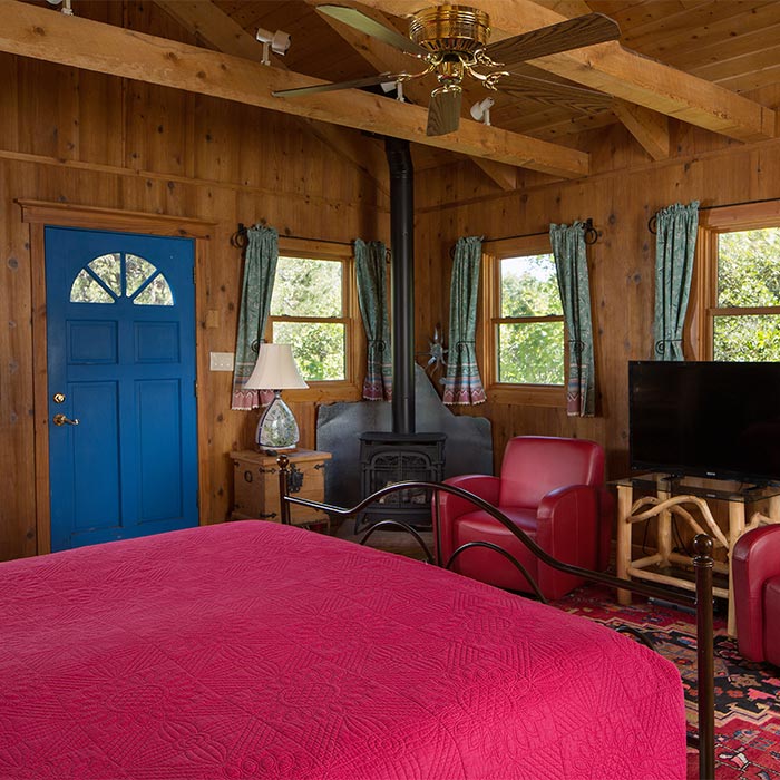 A cabin with a king bed ceiling fam, and flat screen TV