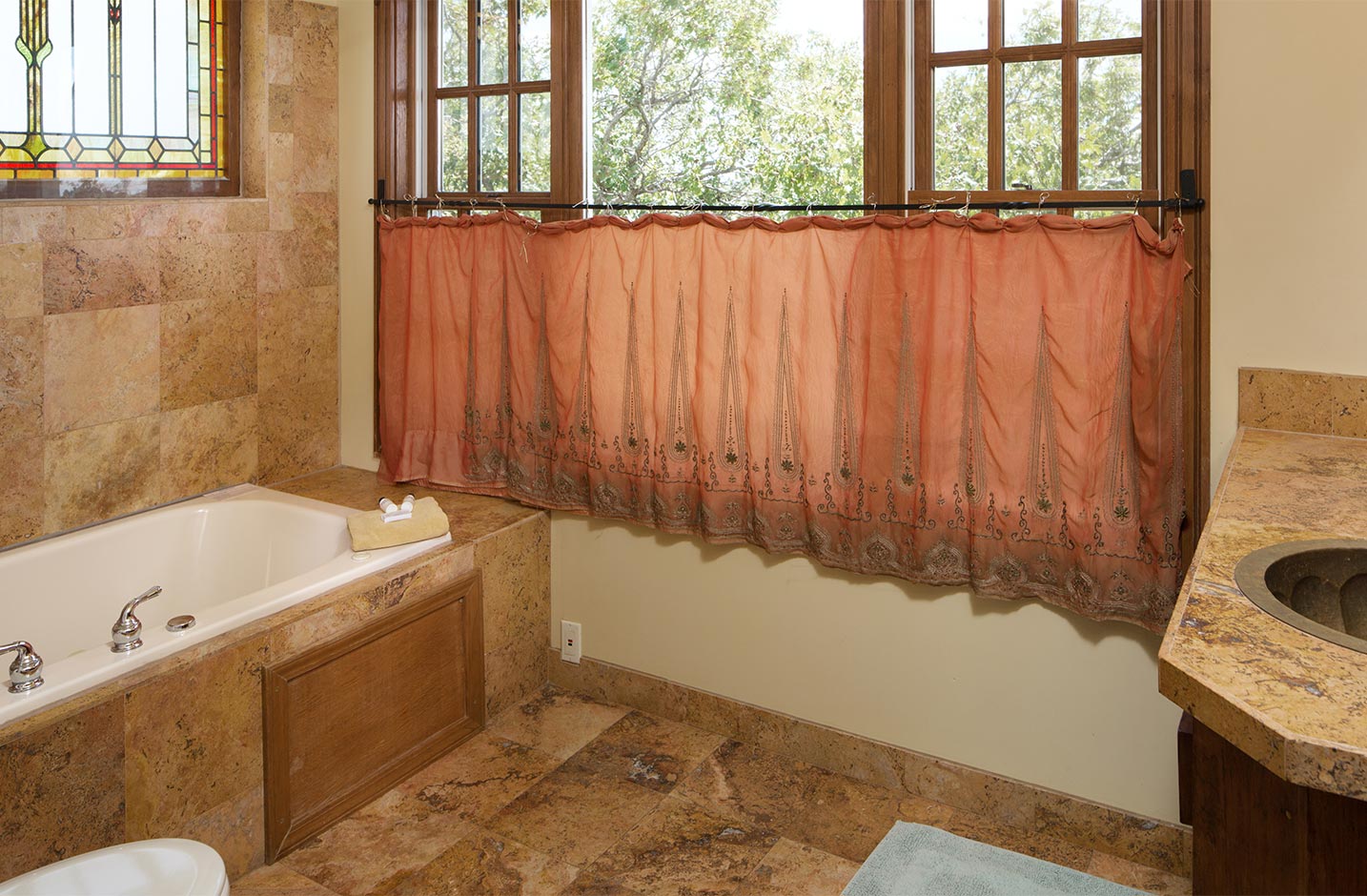 Bathroom with a large tub and windows