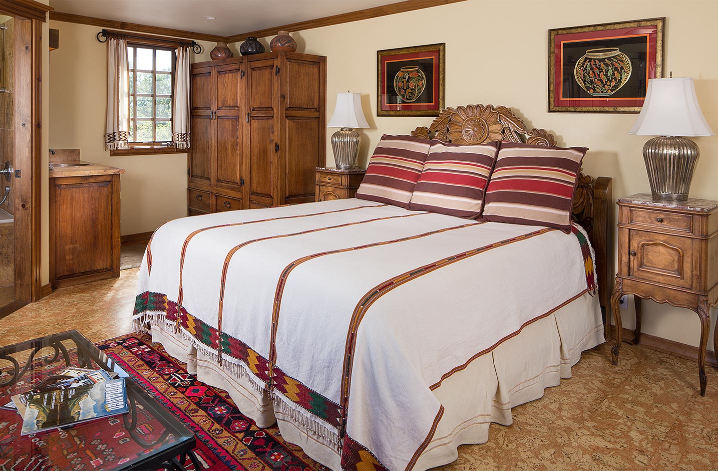 A spacious room with a king bed and side table