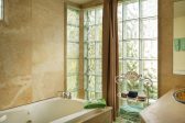A bathroom with glass tile and a large bath tub