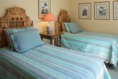 A room with two twin beds and matching teal bed spreads