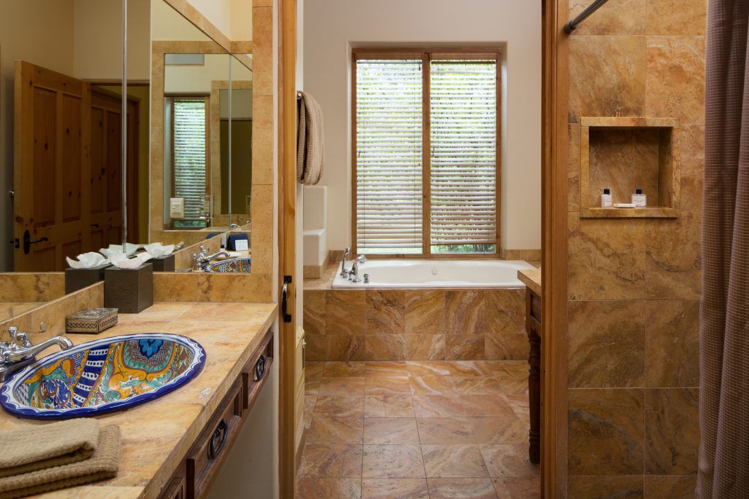 Bathroom with sinks, walk-in shower, and a soaking tub