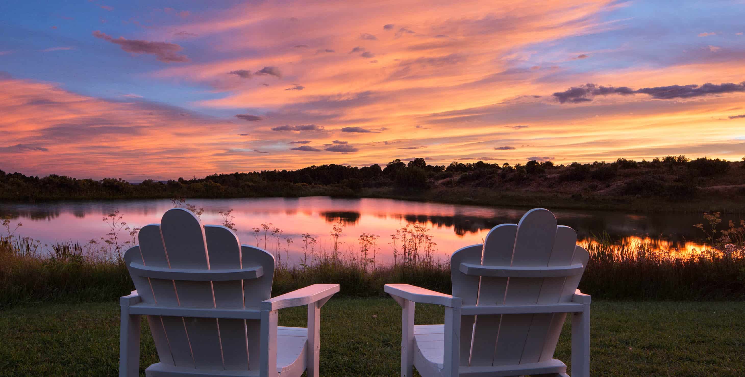 Beautiful sunset of pinks, orange, and blue over blue lake